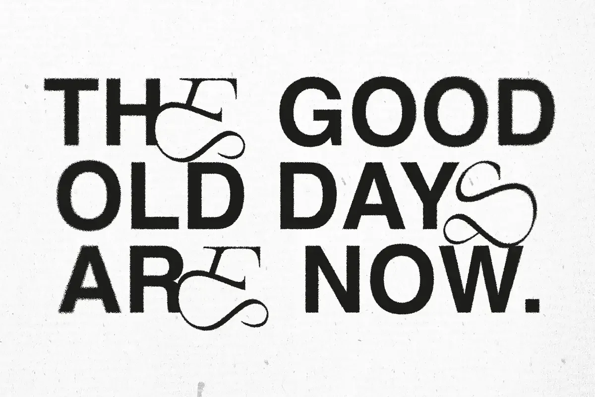 Bold text with intricate ligatures reads "The good old days are now," blending traditional serif with modern decorative elements on a light background.