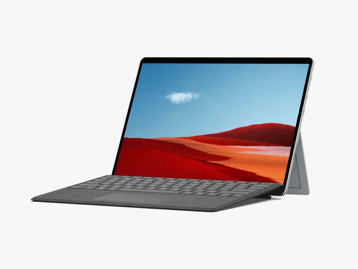 Surface Pro in laptop mode, showcasing a bright red desert landscape on the screen with a sleek gray keyboard.
